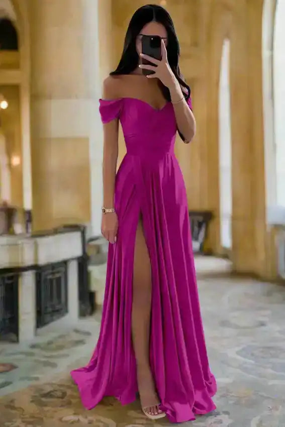 Fuchsia pink off shoulder bridesmaid dress with pleated satin skirt and thigh-high slit, styled for elegant indoor events.