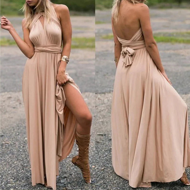 Woman wearing a long beige dress with a slit, standing on a gravel surface.