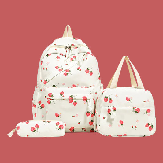 Set of strawberry-patterned bags including a backpack, duffel bag, and pouch on a light purple background