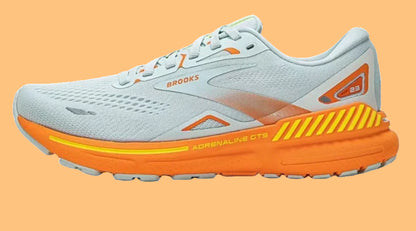 White and orange running shoe with 'Brooks' branding on a white background
