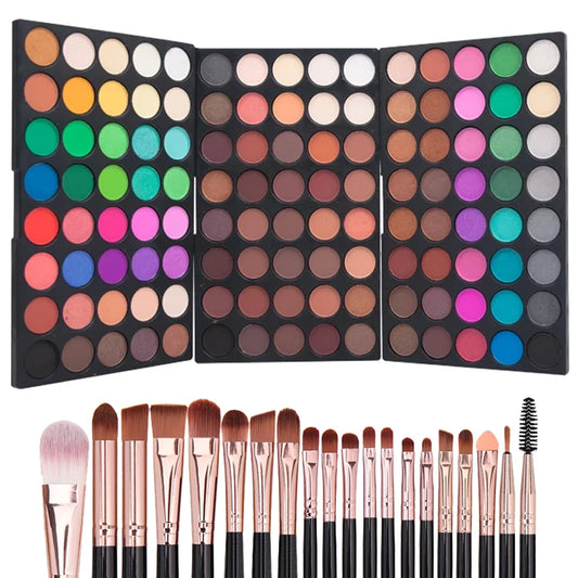 Makeup palette with a variety of colors and makeup brushes on a white background