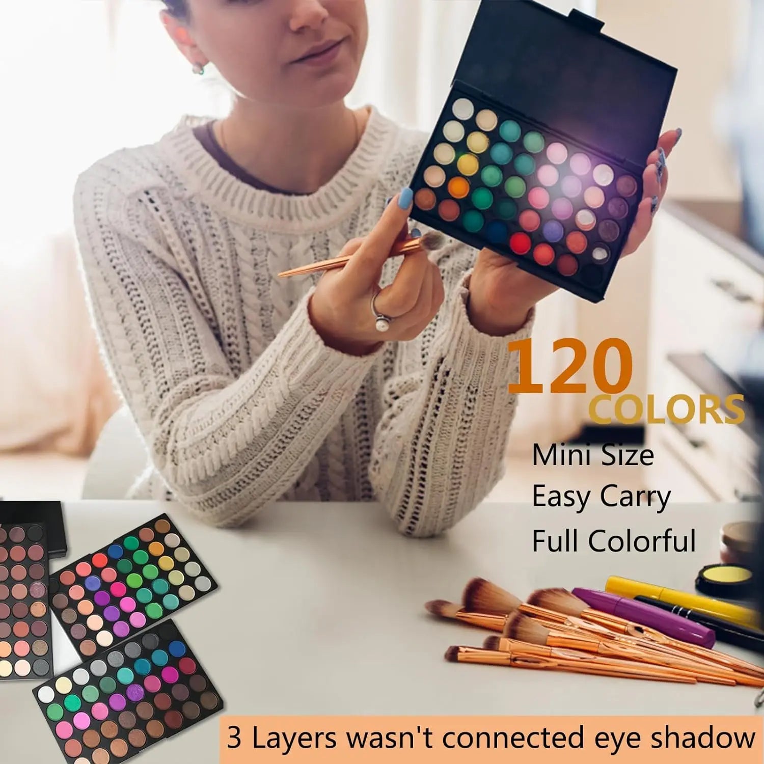 Person holding a makeup palette with multiple colors, surrounded by brushes on a table.