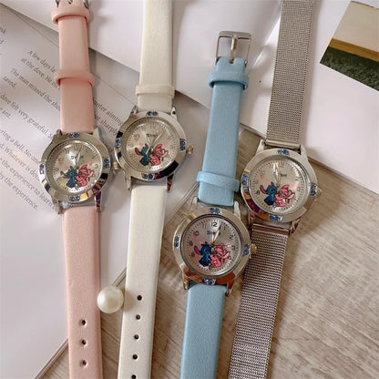 Four watches with different colored straps on a surface.